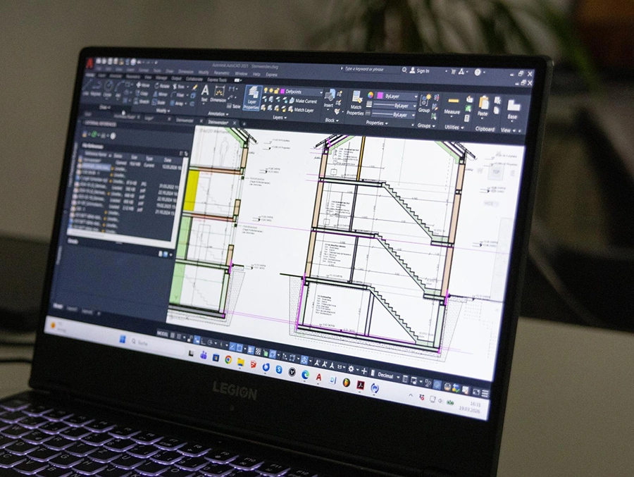 Laptop im Architekturbüro zeigt den Schnitt eines Wohnhauses