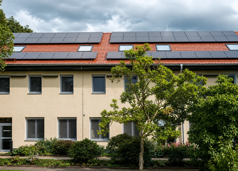 Saniertes Bestandsgebäude mit Photovoltaikanlage auf dem Dach – energetische Sanierung und Modernisierung durch ein Architekturbüro.