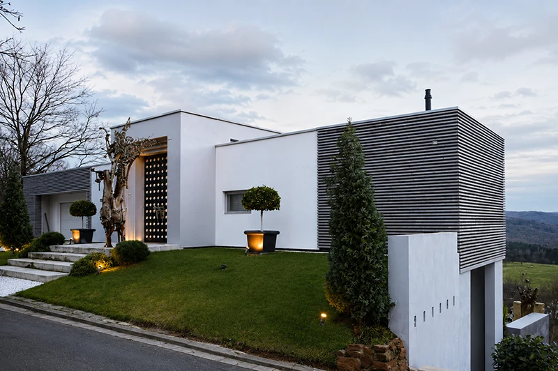 Moderne Stadtvilla mit Flachdach, klarer Formensprache und Holzfassade – individuelle Architekturplanung für hochwertiges Wohnen.