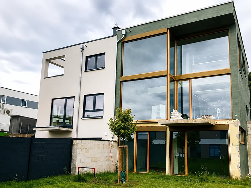Modernes Einfamilienhaus mit großzügiger Glasfassade, kubischer Architektur und klarer Formensprache während der Bauphase.